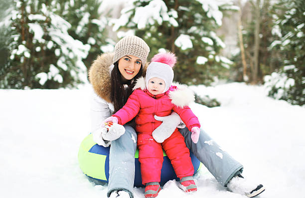 istock Mother and child on sled having fun in winter 535887445