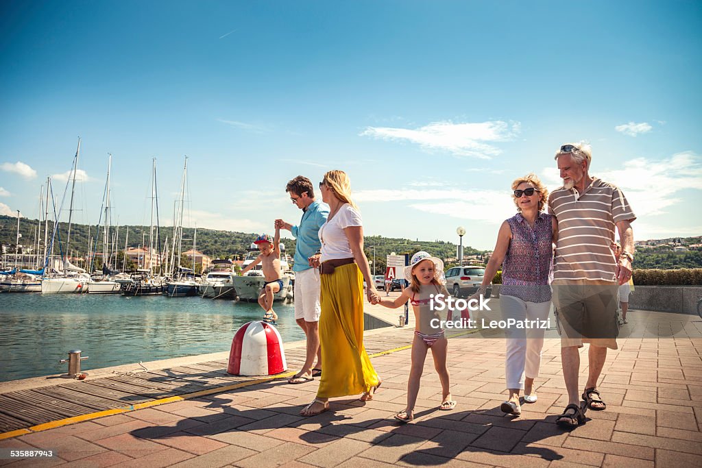 Happy family all together in vacation Happy family all together in vacation. Their walking on the seaside in a small touristic harbor. Family Stock Photo Happy family all together in vacation Happy family all together in vacation. Their walking on the seaside in a small touristic harbor. Family Stock Photo