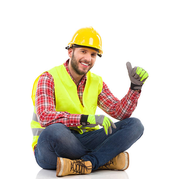 労働者床に座ると親指アップを示す - construction worker building contractor craftsperson full length ストックフォトと画像