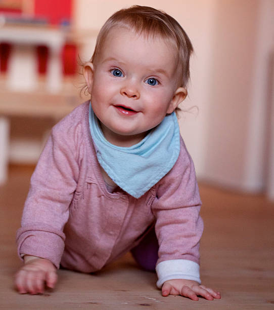 istock Young girl crawls on a hardwood floor. 535890997