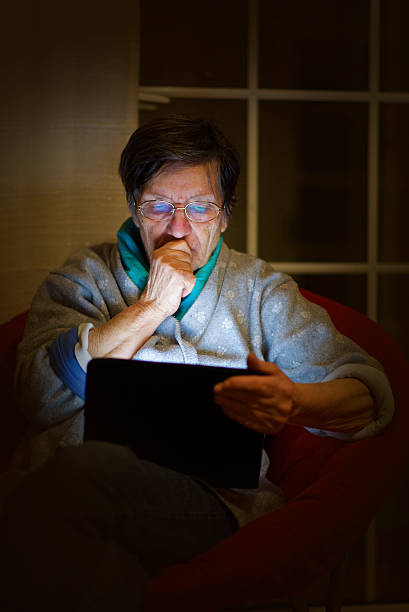 istock granny in the dark lighted by his tablet worried 535892743