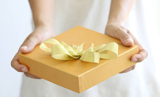 istock Woman holding a gold gift box 535896119