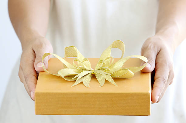 istock Woman holding a gold gift box 535909925