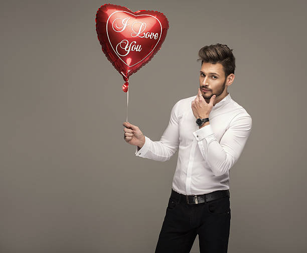 istock Handsome man with balloon heart thinking 535912279