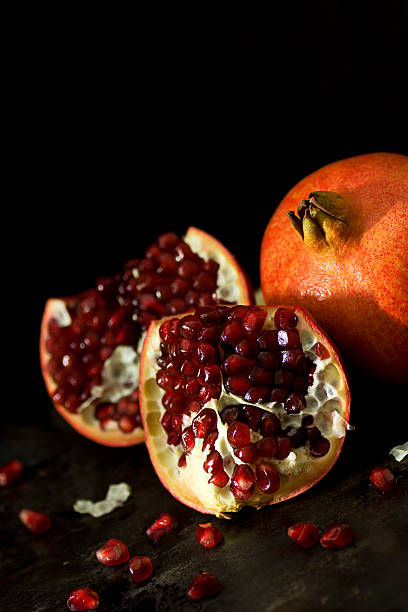 granatäpfel ganzen und gebrochenen offene auf schwarz - chiaroscuro stock-fotos und bilder