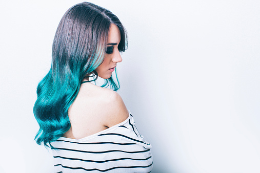 Portraite of a young hipster girl, with a green dyed hair in an Ombre coloring technique