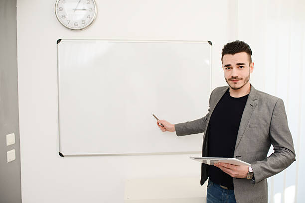 istock young business man or teacher showing data on white board 535918949