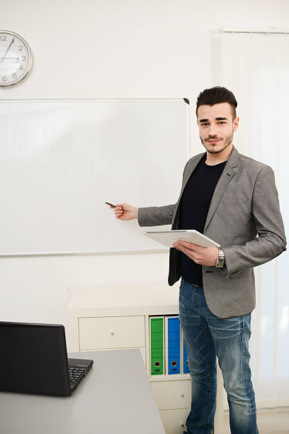 istock young business man or teacher showing data on white board 535918953