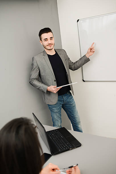 istock young business man or teacher showing data on white board 535918969