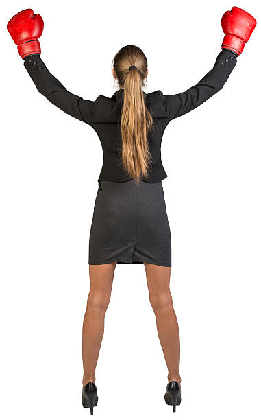 mujer de negocios usando guantes de boxeo wins. vista posterior - back and forwards fotografías e imágenes de stock