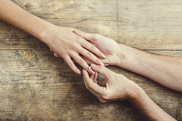 istock Man putting on engagement ring to his woman. 535932685