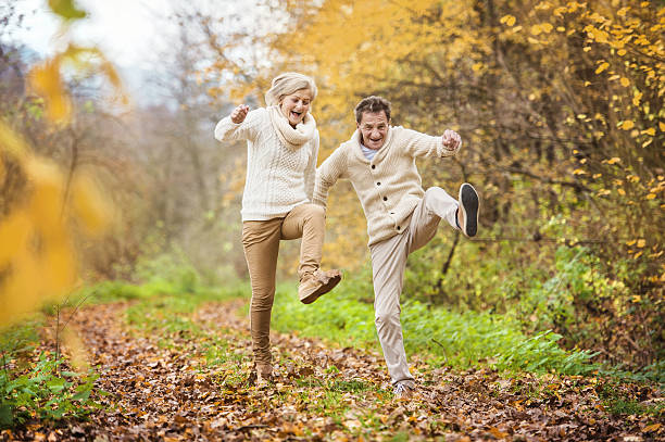 idosos ativos se divertir na natureza - autumn women leaf scarf - fotografias e filmes do acervo