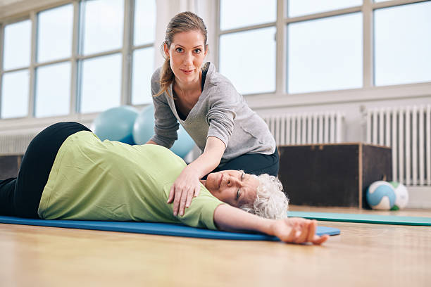 istock Trainer helping senior woman in her stretching workout 535933909