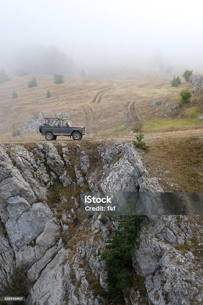 Russian military jeep (UAZ) Russian military jeep (UAZ) on the rock in the fog. Vertical pictures. 2015 Stock Photo