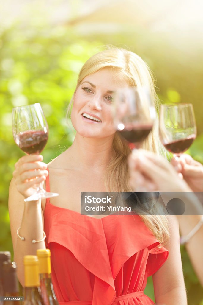 Young Woman in Wine Tasting Subject: A group wine tasting with taster judging the color, sniffing and smelling the aroma of the bouquet. 20-29 Years Stock Photo