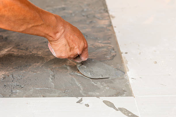 istock Labor installing tile floor for new house building 535939285