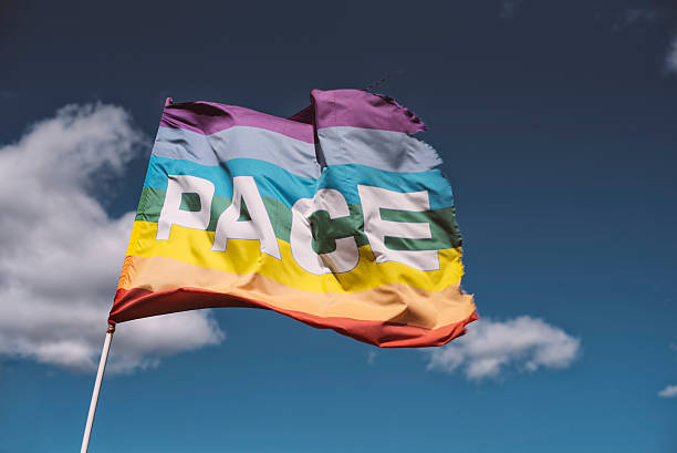 Pace, Peace Flag waving against blue sky stock photo