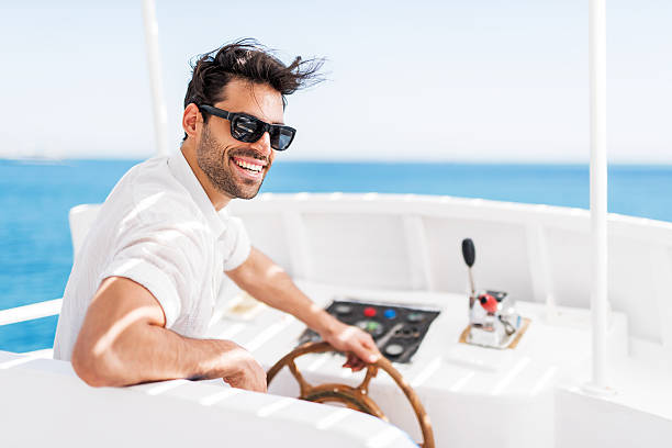Young man driving a boat.