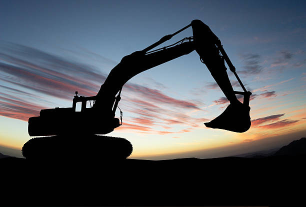 istock silhouette of Excavator loader at construction site with raised 535966265