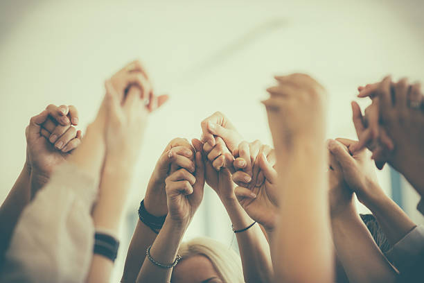 Group of women holding hands. Unity concept Group of women standing toghether in the circle and holding raised hands. Close up of hands. Unrecognizable people.  group therapy photos stock pictures, royalty-free photos & images