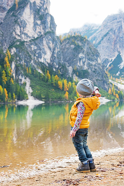 istock Child throwing stones while on lake braies, italy 535969489