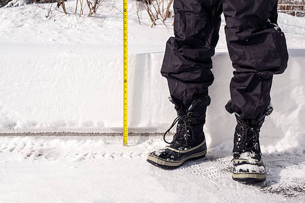 nieve acumulación se mide con cinta amarilla - bota de la nieve fotografías e imágenes de stock