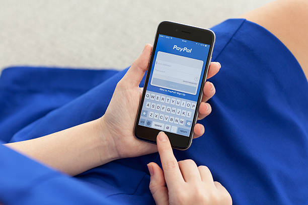 Woman holding iPhone 6 Space Gray with service PayPal stock photo