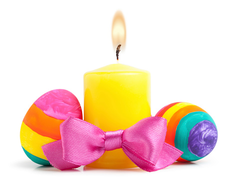 Close up of colorful easter eggs and candle on white background. This file is cleaned, retouched and contains 