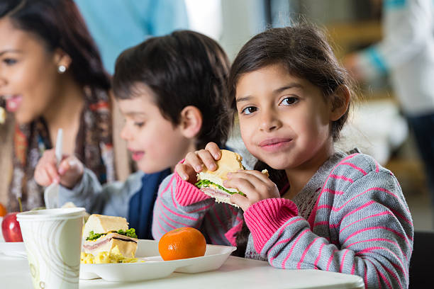 giovane famiglia ispanica mangiare pasto al quartiere mensa per i poveri - childrens food foto e immagini stock