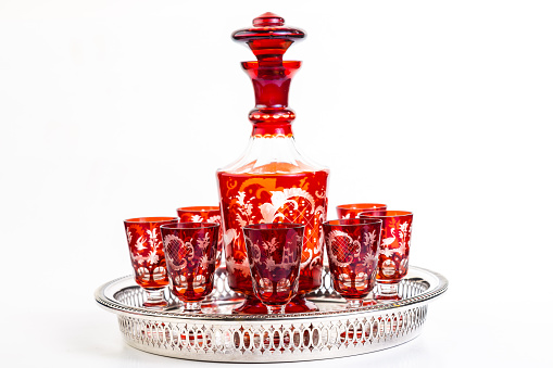 Set of red Bohemiam Cordial Glasses and Decanter in Silver Serving Tray.  Horizontal on white background with copy space.