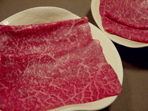 Raw sthin slices of japanese marbled beef ready for cooking shyabu shabu or sukiyaki