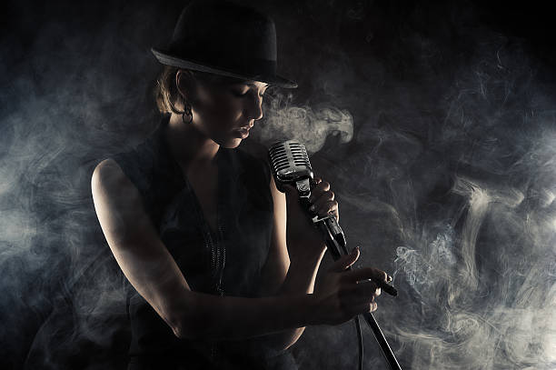 jazz singer woman with retro microphone jazz singer woman with retro microphone on black background smoking women luxury cigar stock pictures, royalty-free photos & images