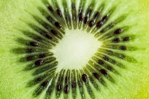 Macro shot of the inctricate pattern on the inside of a kiwi fruit. Extreme close up. Horizontal colour image.