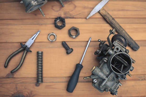 istock Carburetors for a car engine with tools on wooden table 535988743