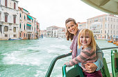 happy mother and baby girl travel by venice water bus