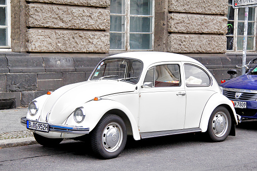 Berlin, Germany - September 12, 2013: White Volkswagen Beetle retro car parked at the city street.