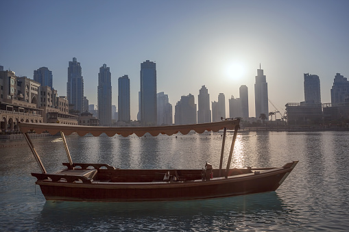 Dubai lagoon with boat against sunset in United Arab Emirates