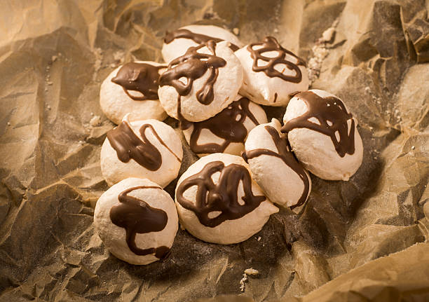 Freshly baked meringues on baking paper stock photo