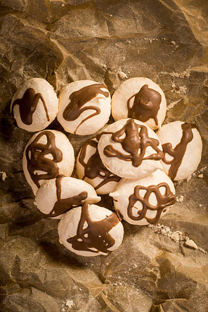 Freshly baked meringues on baking paper stock photo