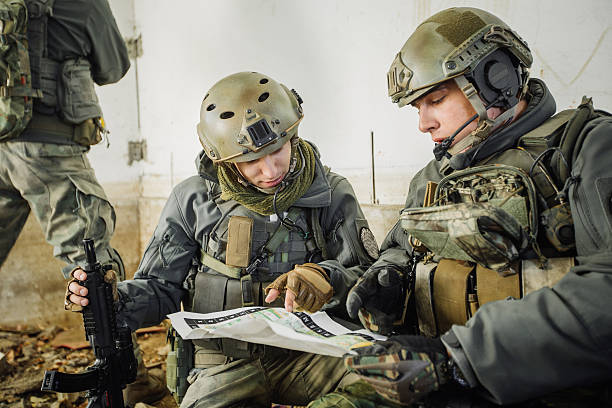солдат в номере, гляд�я на карту - военная подготовка стоковые фото и изображения