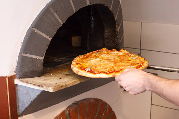 istock Pizza on spade going into traditional wood oven. 536012219