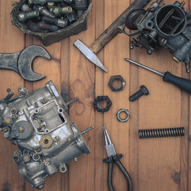 istock Carburetors for a car engine with tools on wooden table 536017301