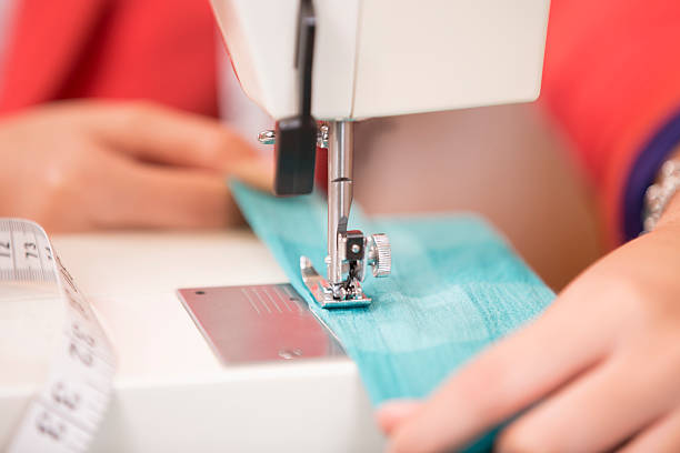 seamstress sews tela, ropa con máquina de coser. primer plano. - craft adult blue busy fotografías e imágenes de stock