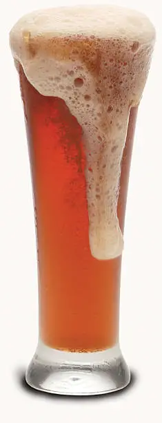 A glass of amber colored beed with a foamy head