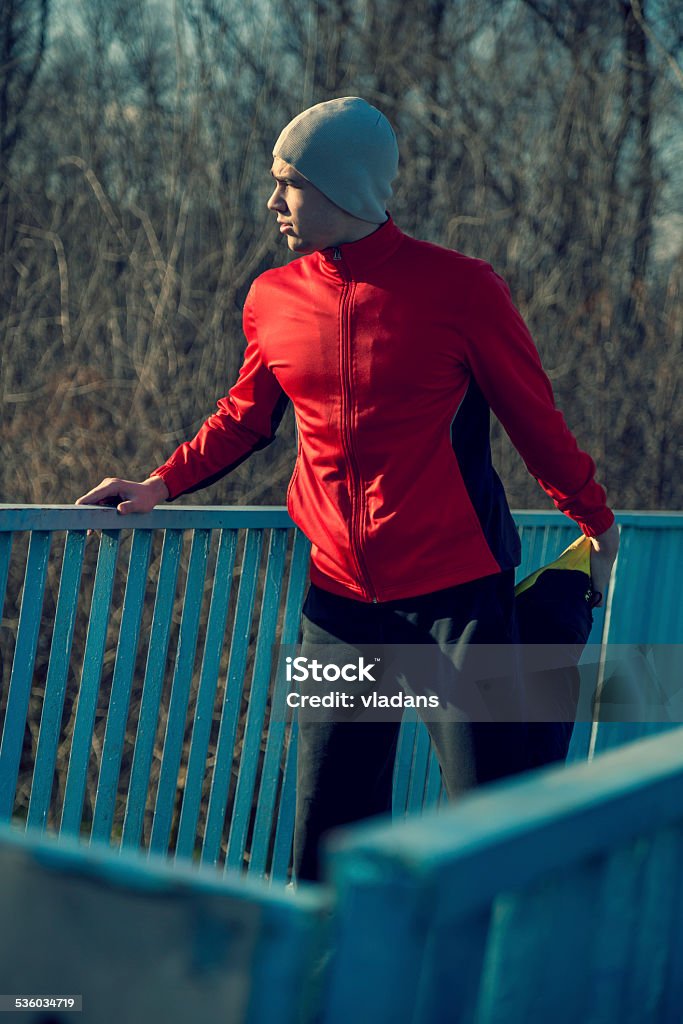 Stretching out Young sportsman working-out in a park, stretching out before running 2015 Stock Photo