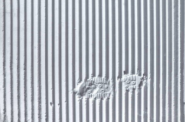 Foot trace on the fresh striped prepared slope, strips lines of snowcat, close up