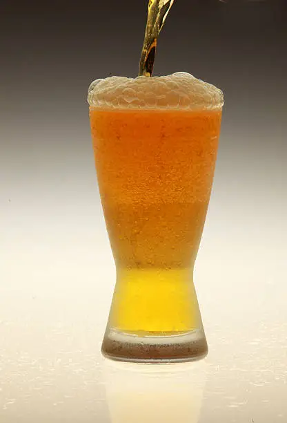  pouring of a beer in to a cold glass