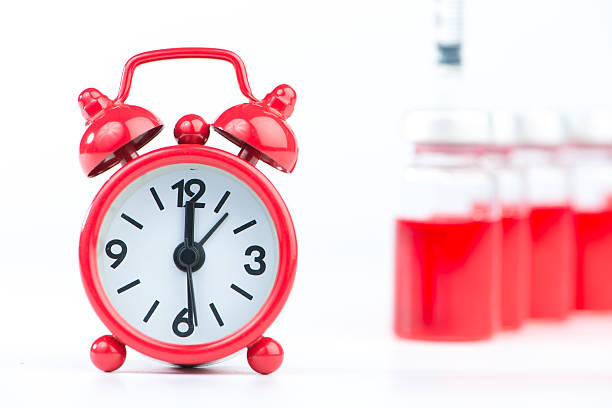 istock Red alarm clock and injection vials background 536049141