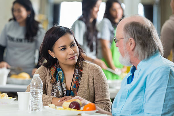 istock Volunteer having meal with senior man at soup kitchen 536050863