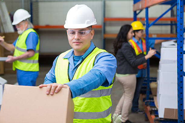 istock Hispanic worker pushing dolly in busy warehouse 536050883